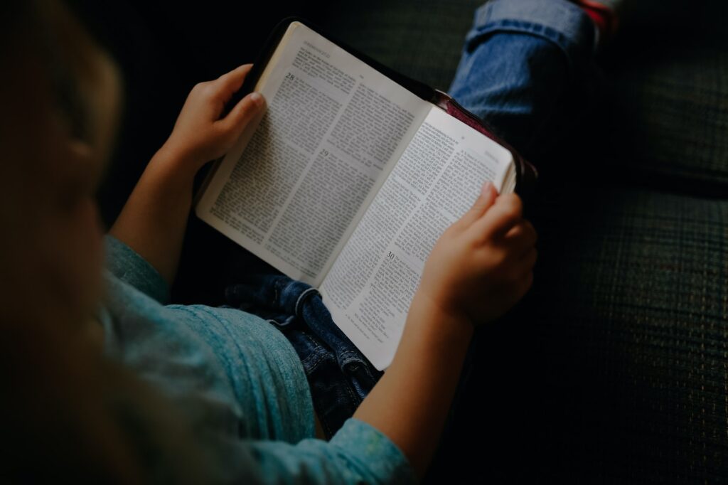 top down view of a child reading a book, head not visible