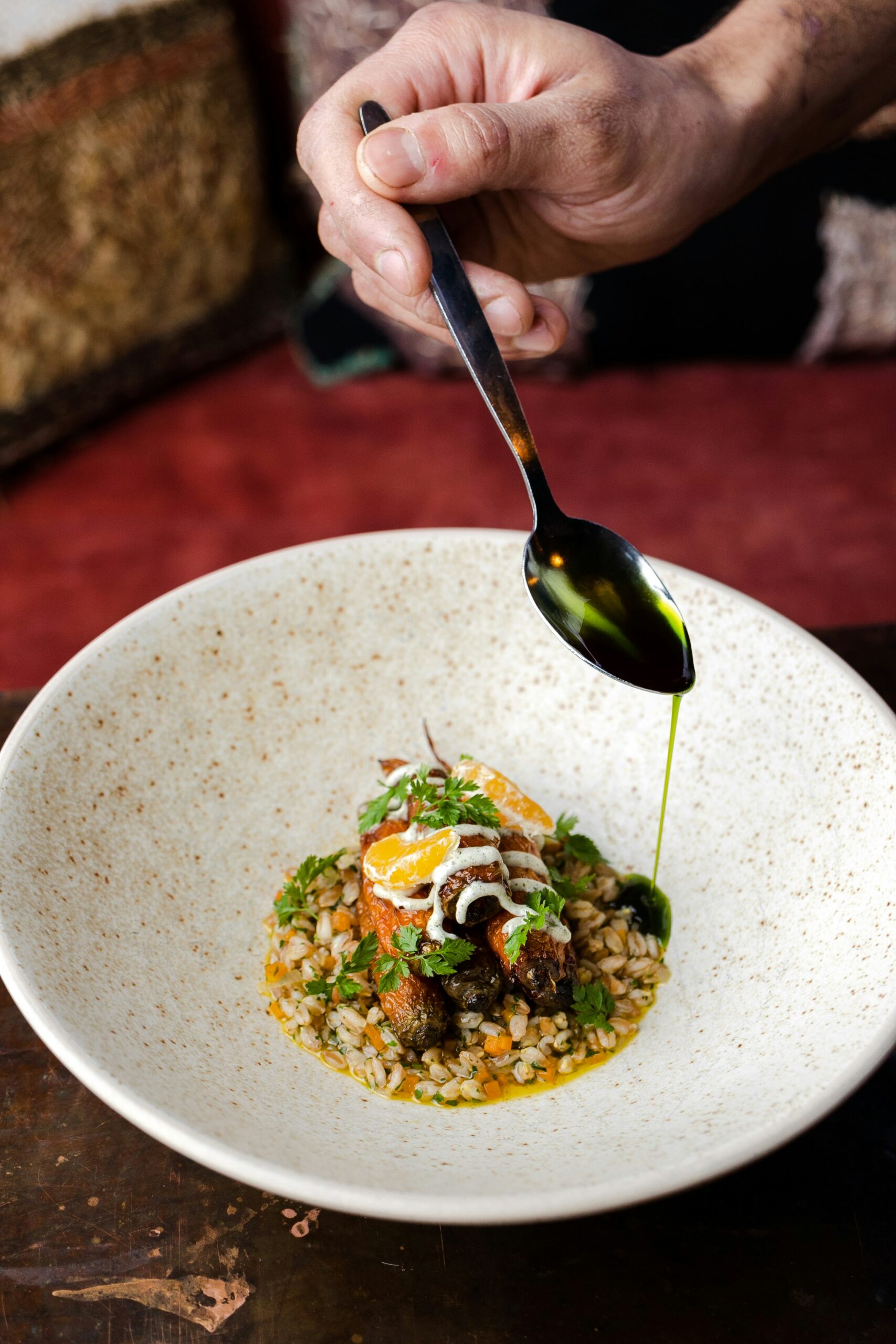 chef drizzling something on a meal