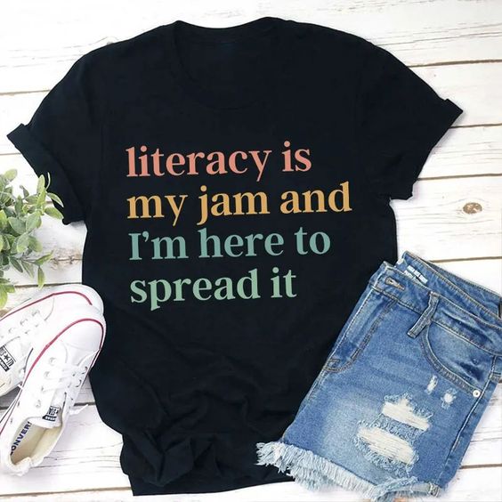 shirt says "literacy is my jam and I'm here to spread it"